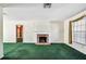 Spacious living room with a brick fireplace, green carpet, and built-in shelving visible through an open doorway at 10314 Lake Carroll Way, Tampa, FL 33618