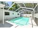 Large screened-in pool with ladder and entry stairs featuring white vinyl enclosure and concrete patio at 10314 Lake Carroll Way, Tampa, FL 33618