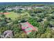 Aerial view of tennis courts surrounded by lush trees showcases recreational amenities at 10314 Lake Carroll Way, Tampa, FL 33618
