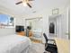 Bright bedroom featuring a mirrored closet, ceiling fan, and wood flooring at 10821 101St Ave, Seminole, FL 33772