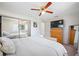 A bright bedroom with a ceiling fan, wooden dresser, and large closet mirror at 10821 101St Ave, Seminole, FL 33772