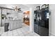Bright kitchen with white tile flooring, gray cabinets, and a modern black refrigerator at 10821 101St Ave, Seminole, FL 33772