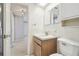 A compact bathroom featuring tiled walls, neutral fixtures, and a wood-finished vanity at 1153 Honor Dr, Holiday, FL 34690