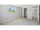 Bright bedroom featuring a large window, mirrored closet, and neutral carpet at 1153 Honor Dr, Holiday, FL 34690