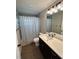Bathroom featuring a single sink vanity, a toilet and a shower with a patterned shower curtain at 12021 Coleman Ave, Port Charlotte, FL 33981