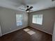 This bedroom includes wood-look tile flooring, two windows, ceiling fan, and neutral color paint at 12021 Coleman Ave, Port Charlotte, FL 33981