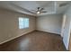 Spacious bedroom features wood-look tile flooring, a tray ceiling, and a ceiling fan at 12021 Coleman Ave, Port Charlotte, FL 33981