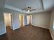 Large bedroom has wood-look tile, a ceiling fan, and multiple doors leading to the en suite bathroom and closet at 12021 Coleman Ave, Port Charlotte, FL 33981