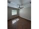 This bedroom features wood-look tile, a ceiling fan, neutral paint, and a sun-filled window at 12021 Coleman Ave, Port Charlotte, FL 33981