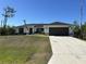 Beautiful home featuring a two-car garage, well-maintained lawn, and an American flag at 12021 Coleman Ave, Port Charlotte, FL 33981