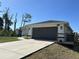 Nice one story home featuring a modern two car garage and neutral color palette with a well kept lawn at 12021 Coleman Ave, Port Charlotte, FL 33981