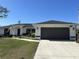 Charming home featuring a two-car garage, well-maintained lawn, and an American flag at 12021 Coleman Ave, Port Charlotte, FL 33981