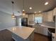Bright kitchen featuring white cabinets, modern appliances, large island, and stylish pendant lighting at 12021 Coleman Ave, Port Charlotte, FL 33981