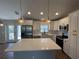 Modern kitchen with white cabinets, stainless steel appliances, island, and decorative pendant lighting at 12021 Coleman Ave, Port Charlotte, FL 33981