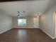 Open-concept living area with tile floors, a ceiling fan, and ample natural light from a front facing window at 12021 Coleman Ave, Port Charlotte, FL 33981