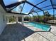 This screened-in in-ground pool is surrounded by pavers and ample entertaining space at 12021 Coleman Ave, Port Charlotte, FL 33981