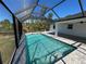 This screened-in in-ground pool is surrounded by pavers and ample entertaining space at 12021 Coleman Ave, Port Charlotte, FL 33981