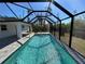 The in-ground pool features pavers, screened in enclosure, and ample space at 12021 Coleman Ave, Port Charlotte, FL 33981