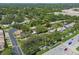 Aerial view showcases townhomes surrounded by mature trees and roadways in a suburban setting at 1236 Abbey Crescent Ln, Clearwater, FL 33759