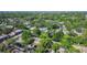 Aerial view of townhomes surrounded by lush trees with a glimpse of a distant skyline at 1236 Abbey Crescent Ln, Clearwater, FL 33759