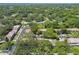 Aerial view revealing townhomes nestled among green trees, with winding roads and community landscaping at 1236 Abbey Crescent Ln, Clearwater, FL 33759