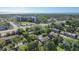 Aerial view showcases a community near coastal waters, featuring mature trees and multi-story buildings at 1236 Abbey Crescent Ln, Clearwater, FL 33759