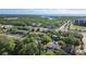 Aerial view displaying townhomes surrounded by green trees, near a serene lake and roadways at 1236 Abbey Crescent Ln, Clearwater, FL 33759