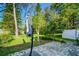 View of the paved area surrounded by trees and green grass from the backyard at 1236 Abbey Crescent Ln, Clearwater, FL 33759