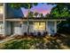 A charming townhome entrance highlighted by lush greenery and colorful landscaping in evening light at 1236 Abbey Crescent Ln, Clearwater, FL 33759