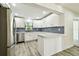 Bright kitchen with white cabinets, stainless steel appliances, and light countertop peninsula at 1236 Abbey Crescent Ln, Clearwater, FL 33759