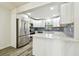 Kitchen featuring white cabinets, stainless steel appliances, and a breakfast bar with light counter at 1236 Abbey Crescent Ln, Clearwater, FL 33759