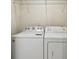 A white washer and dryer with white wire shelving above provide convenient laundry facilities at 1236 Abbey Crescent Ln, Clearwater, FL 33759
