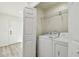 Laundry room with a newer washer and dryer, with shelving for easy and convenient storage at 1236 Abbey Crescent Ln, Clearwater, FL 33759