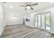 A spacious room features wood-look floors, recessed lighting, and sliding glass doors to a patio at 1236 Abbey Crescent Ln, Clearwater, FL 33759