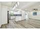 Open-concept living room featuring gray flooring, ceiling fan, modern lighting, and modern kitchen at 1236 Abbey Crescent Ln, Clearwater, FL 33759