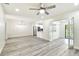 Bright open-plan living room featuring gray flooring, ceiling fan and modern kitchen appliances at 1236 Abbey Crescent Ln, Clearwater, FL 33759