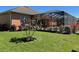 Lush backyard featuring well-maintained lawn, flowering bushes, and a screened-in pool area at 12619 50Th E Ct, Parrish, FL 34219