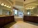 Luxurious bathroom with dual vanities, a soaking tub, and decorative lighting fixtures at 12619 50Th E Ct, Parrish, FL 34219