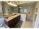 Modern bathroom featuring dual sinks with granite countertops, tiled walk-in shower, and plenty of light at 12619 50Th E Ct, Parrish, FL 34219