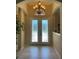 Grand foyer with decorative glass doors, chandelier, neutral walls, and ceramic tile flooring at 12619 50Th E Ct, Parrish, FL 34219