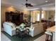 Open living room with ceiling fan, neutral decor, comfortable seating, and view to the kitchen at 12619 50Th E Ct, Parrish, FL 34219