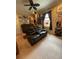 Relaxing living room with leather sofa, ceiling fan, and memorabilia displayed on the walls at 12619 50Th E Ct, Parrish, FL 34219