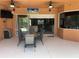 Outdoor patio features a ceiling fan, dining table and chairs, and built-in grill at 12619 50Th E Ct, Parrish, FL 34219