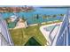 Aerial view of a waterfront property with a pool, dock, and lush lawn, ideal for outdoor living at 12650 7Th E St, Treasure Island, FL 33706