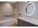 Stylish bathroom with illuminated mirror, neutral decor, and soaking tub at 12650 7Th E St, Treasure Island, FL 33706