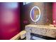 Chic powder room featuring a unique stone sink, designer mirror and purple accent wall at 12650 7Th E St, Treasure Island, FL 33706