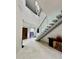 Spacious entryway with high ceilings, modern staircase and elegant light fixture at 12650 7Th E St, Treasure Island, FL 33706