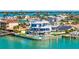 Waterfront home with multiple balconies, a dock, and a pool offers an amazing view of the serene surroundings at 12650 7Th E St, Treasure Island, FL 33706