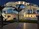 A beautifully illuminated home with a unique design at night, enhanced by a dockside view at 12650 7Th E St, Treasure Island, FL 33706