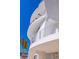 Modern condo with rounded balcony, steel railings, and white concrete architecture under a clear blue sky at 12650 7Th E St, Treasure Island, FL 33706